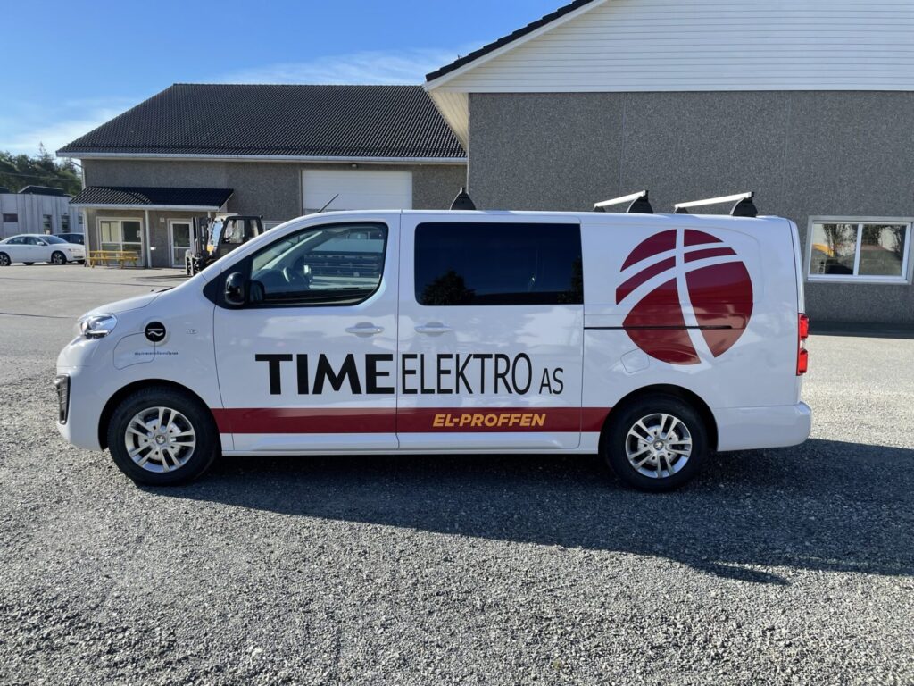 Hvit Time Elektro-varebil med logo og rød og svart bildekor
