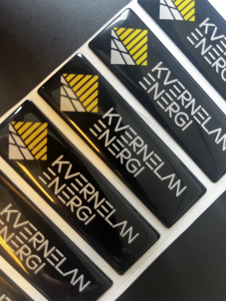 Svarte Kverneland Energi-merker med gul og hvit logo og blank overflate